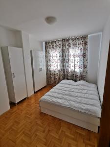sypialnia z białym łóżkiem i oknem w obiekcie 007 Apartments - TC Global, Strumica, Macedonia w mieście Strumica