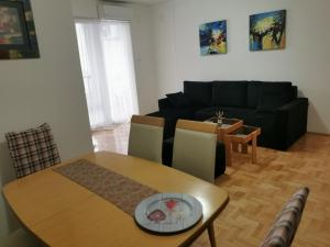 sala de estar con mesa y sofá negro en 007 Apartments - TC Global, Strumica, Macedonia, en Strumica
