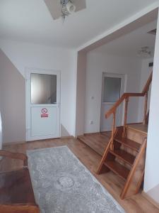 a living room with a staircase and a stair case at Casa Bucovina Dorna Candrenilor in Ascuţitele