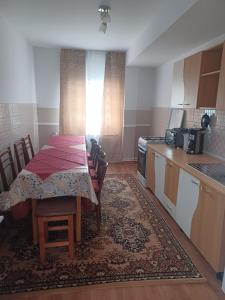 a kitchen with a table with chairs and a kitchen with a tableablish at Casa Bucovina Dorna Candrenilor in Ascuţitele