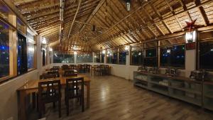 a restaurant with wooden tables and chairs in a room at The Tiger Claw Resort in Rāmnagar
