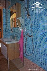 a bathroom with a shower with a pink towel at Villa Nur - Lake View Apartaments in Mavrovi Anovi