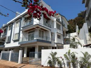 un edificio blanco con flores rojas. en Antalya Villa - 5BHK with Private Pool, Baga en Baga
