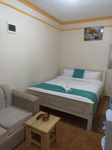 a small bedroom with a bed and a couch at Essie Studios Naivasha CBD in Naivasha