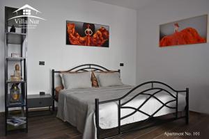 a bedroom with a bed with three pictures on the wall at Villa Nur - Lake View Apartaments in Mavrovi Anovi