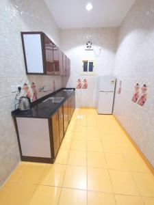 una cucina con lavandino e frigorifero di سارة للشقق المفروشة - الحمدانية جدة a Ḩayy aş Şāliḩīyah
