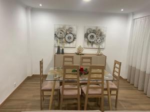 a dining room with a glass table and chairs at Casa Julita con Parking in Elche