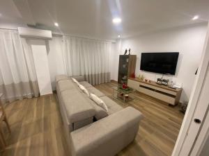 a living room with a couch and a flat screen tv at Casa Julita con Parking in Elche