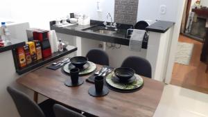 una mesa con platos y sombreros encima en Flat Quatre Saisons - Apartamento em Campos do Jordão, en Campos do Jordão