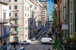 une rue urbaine remplie de voitures et de bâtiments dans l'établissement MolteVolte Rooms, à Palerme