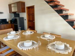 una mesa de comedor con platos y vasos. en High Life Villas, en Salad Beach