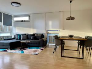 een woonkamer met een bank en een tafel bij LaMiaCasa Design Apartment near Ludwigsburg 2,5 rooms 75 sqm in Schwieberdingen