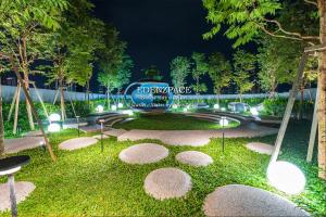 a park at night with a sign in the grass at Scarletz Suites by Edenzpace @ KLCC Area in Kuala Lumpur
