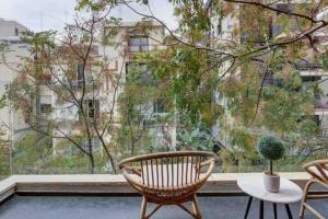 a balcony with a chair and a table and a large window at Luxury 3 Bedrooms Apt near Hilton hotel in Tel Aviv