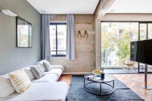 a living room with a white couch and a tv at Luxury 3 Bedrooms Apt near Hilton hotel in Tel Aviv