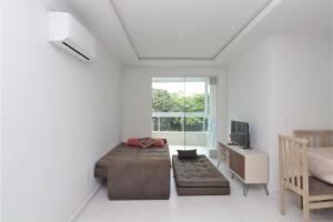 Habitación con cama, TV y sofá. en Localização privilegiada para 7 pessoas - NY02H, en Florianópolis