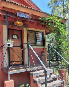 ein kleines Haus mit einer Veranda und einer Tür in der Unterkunft Toca Madera in Merlo