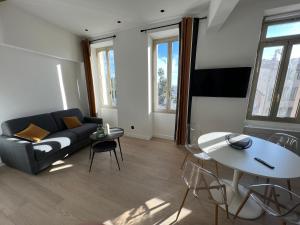 sala de estar con sofá y mesa en Appartement 33 m2 comme une junior suite - vue Port et Palais des festivals, en Cannes
