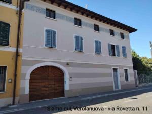 a large white building with a brown garage at La Rovettina in Verolanuova