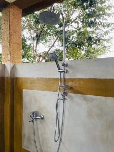 ducha con cabezal de ducha en la pared en Rock Shade Chalet- Sigiriya en Sigiriya