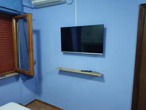 a flat screen tv hanging on a wall with a shelf at Affittacamera Mauro vasto in Vasto