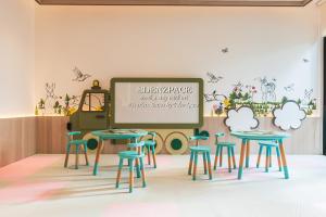 a classroom with tables and stools in front of a chalkboard at Scarletz Suites by Edenzpace @ KLCC Area in Kuala Lumpur