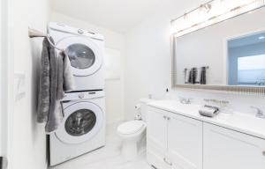 uma casa de banho branca com uma máquina de lavar e secar roupa em LA Retreat em Los Angeles