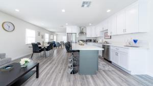 a kitchen with white cabinets and a table and chairs at LA Retreat in Los Angeles