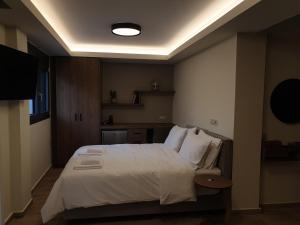 a bedroom with a large bed with white sheets and pillows at Olive Deluxe Room in Kardítsa