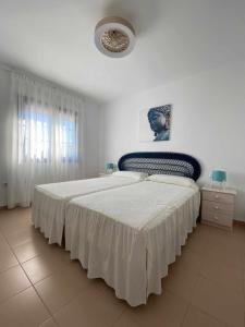 a bedroom with a large bed with a white spread at Apartamento Panoramico Tres Pinos Piscina in San José +15 photos