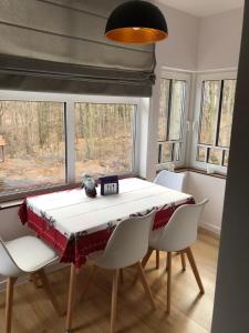 uma sala de jantar com mesa, cadeiras e janelas em Przystanek Karpacz em Karpacz