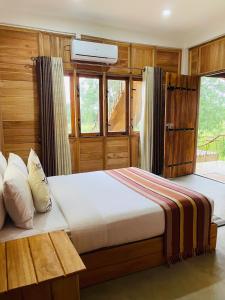 a bedroom with a bed and a window at Rock Shade Chalet- Sigiriya in Sigiriya