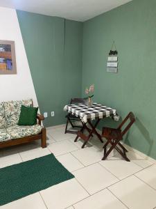 a living room with a table and a couch at Casa aconchegante e charmosa à 6 min da Praia - Ar condicionado - WIFI 600MB - Netflix - Globoplay - Cozinha Completa in Rio das Ostras