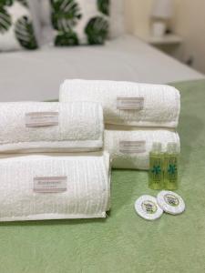 a pile of towels sitting on top of a table at Casa aconchegante e charmosa à 6 min da Praia - Ar condicionado - WIFI 600MB - Netflix - Globoplay - Cozinha Completa in Rio das Ostras