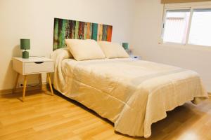 a bedroom with a bed with a night stand and a window at Al pie del Camarín con parking gratis in Jaén