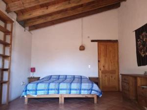 1 dormitorio con 1 cama y puerta de madera en La casa de Buenavista. 