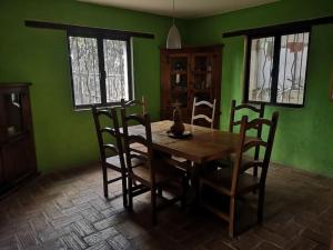 uma sala de jantar com paredes verdes e uma mesa e cadeiras de madeira em La casa de Buenavista. 