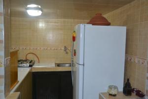 a kitchen with a white refrigerator and a sink at Downtown Apartment in Rabat