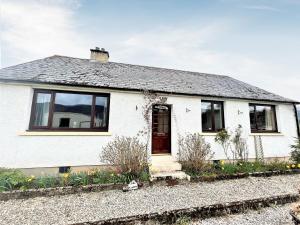 a white house with windows on a gravel road at Westerdale in Fort Augustus