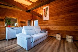 una sala de estar con un sofá azul en una cabaña de madera en Casa di Piero e Marilena, en Candelo