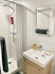 a bathroom with a sink and a shower with a mirror at Entre Paris, Versailles et La Défense in Chaville