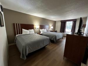 a hotel room with two beds and a flat screen tv at Econo Lodge Inn & Suites in Chambersburg