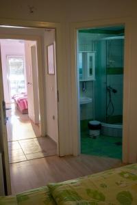 Habitación con baño con ducha y dormitorio. en Villa In Apartments, en Ohrid