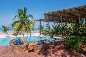 a resort with a swimming pool with chairs and the beach at My Blue Hotel Holbox in Holbox Island