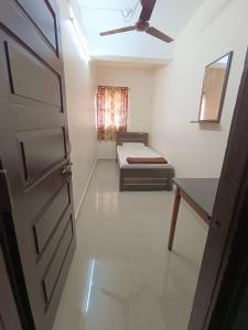 Cette chambre dispose d'une porte, d'un lit et d'une fenêtre. dans l'établissement Shri Vasant Lodge, à Hubli