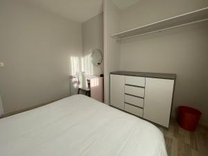 1 dormitorio con cama blanca y armario en Chambre chez l'habitant 1, en Moumour