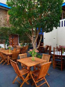 a group of wooden tables and chairs under a tree at Estrella de Belem B&B and Spa in Cholula