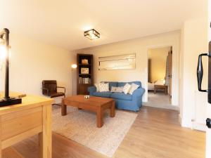 a living room with a blue couch and a table at The Annexe in Wisley