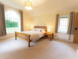 a bedroom with a bed and two windows at The Annexe in Wisley