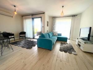 un salon avec un canapé bleu et une télévision dans l'établissement Luxury and comfortable villa with a view, à Milas